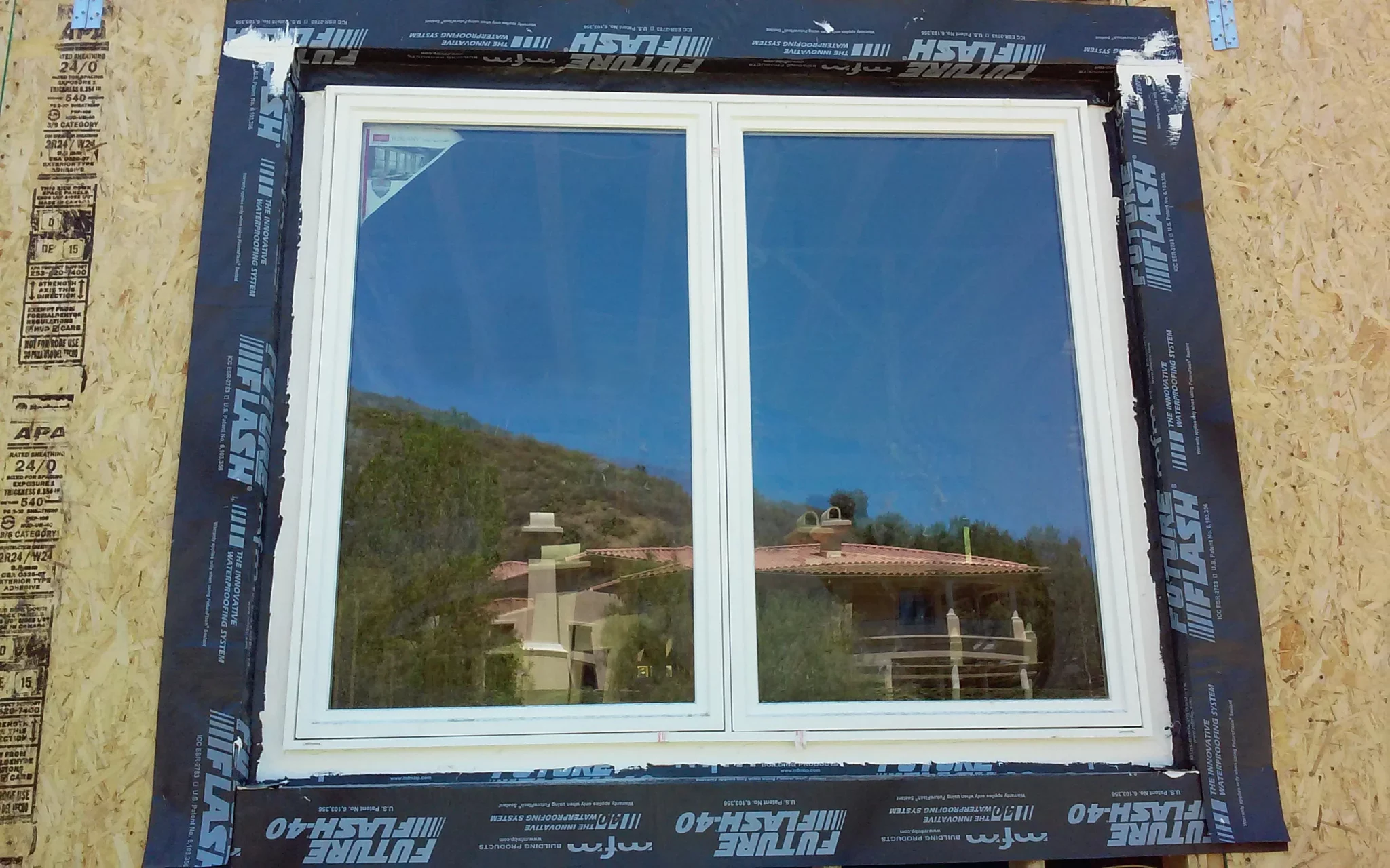 A San Francisco Bay Area Waterproofing company is installing a window in a house.